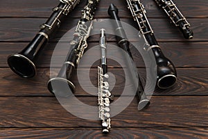 Woodwind instruments lie on a wooden surface. View from above