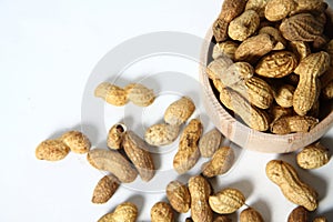 Woodwn bowl of peanuts on white background flat lay