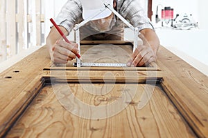 Woodwork concept, carpenter with the meter makes the shape of a