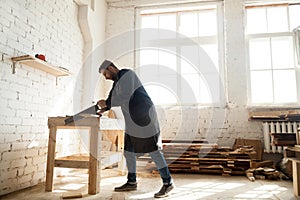 Woodwork and construction. Carpenter using handsaw for sawing wo