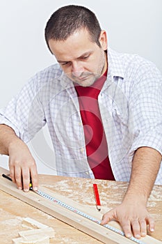 Woodwork - man measuring wooden planck photo