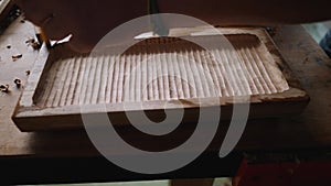 A woodworker applies the wood impregnation to the walnut board with a brush. artisan makes a tray. vagatabon