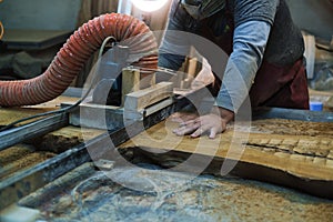 The woodworker carefully cuts through the timber, shaping a future piece of art. Every cut is a step towards the final