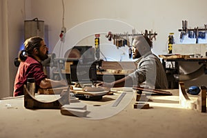 Woodworker and coworker using CAD software on laptop photo