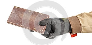 Woodworker hand in black protective glove and brown uniform holding wooden bar with used sandpaper isolated on white background