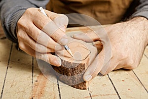 Woodworker hands sketching on wood billet photo