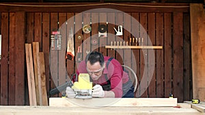 Woodworker processes wood with a milling machine in his carpentry workshop