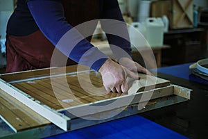 A woodworker sets a burl wood piece in place, ready for resin casting. This image captures the harmony of natural