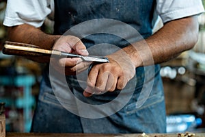 Closeup of Carpenter's Hand Sharpening Chisel