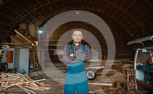 Woodworker in uniform at his workplace, lumbermill