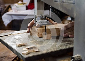 Woodworker Using The Bandsaw On Piece Of Wood photo