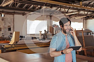 Woodworker using a cellphone and tablet in his workshop