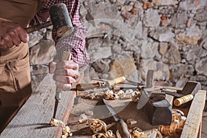 Woodworker using chisel to smooth down wood photo