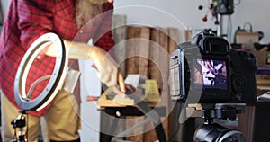 Woodworking vlogging, man cutting wood plank, filming using smartphone an dslr