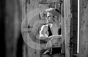 Woodworks concept. Scaffolding and frameworks. Handsome builder at construction site. Guy works at construction