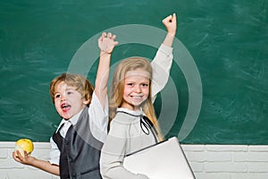 Woohoo. Cheerful smiling child at the blackboard. Schoolchild. Book school and kids. Classroom. School lessons. Yeah