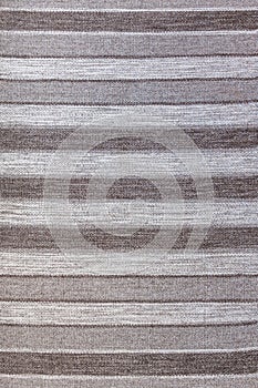 Wool rustic rug with gray, white and black stripes, texture background