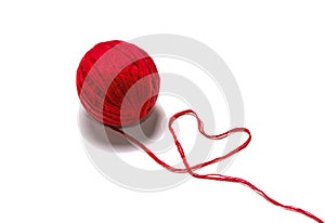 Wool skein red thread in the shape of heart on white background