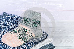 Wool socks and stack of various sweaters. Winter style. Isolated on white