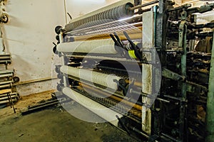 Wool thread production line. Spinning machinery with spindles and wool yarns