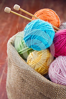 Woolen balls of yarn in a rustic craft bag