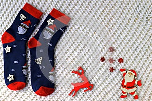 Woolen socks with Christmas pattern, Santa Claus, Saint Nicholas, and New Year s decorations lie on white background. Christmas