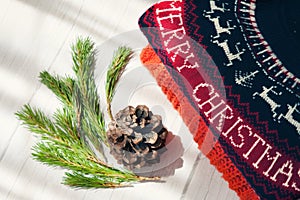 Woolen sweaters with Christmas pattern stacked and space for text on gray wooden background