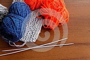 Woolen thread, knitting, knitting needles on wooden table