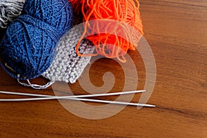 Woolen thread, knitting, knitting needles on wooden table