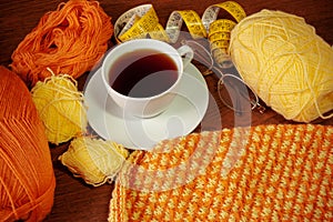 Woolen yarn, knitting,cup of tea, glasses and measuring tape