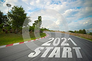 Word 2021 start written on road of racetrack straight to mountain. New year 2021 or start straight concept. Concept of planning