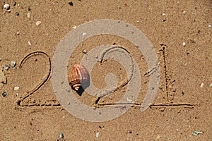 Word 2021 Written on the Sand of a Beach. New Year 2021 text on the sea beach