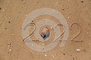 Word 2022 Written on the Sand of a Beach. New Year 2022 text on the sea beach