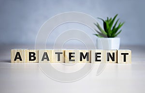 The word ABATEMENT written on wooden cubes on a blue background
