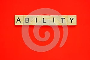 Word ability. Top view of wooden blocks with letters on red surface