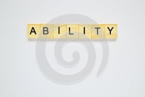 Word ability. Top view of wooden blocks with letters on white surface