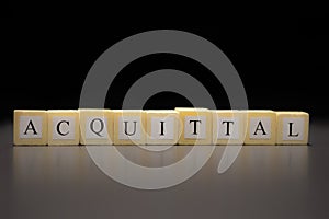 The word ACQUITTAL written on wooden cubes, isolated on a black background photo