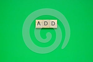 Word add. Top view of wooden blocks with letters on green surface