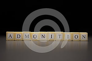 The word ADMONITION written on wooden cubes isolated on a black background