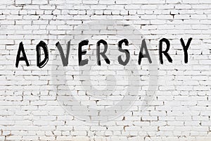 Word adversary painted on white brick wall photo