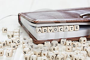 Word ADVOCATE on old wooden table. photo