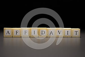 The word AFFIDAVIT written on wooden cubes isolated on a black background