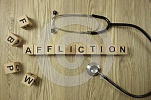 Word affliction from wooden blocks with stethoscope