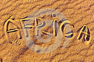 The word Africa - inscription on the golden sand of Sahara Desert