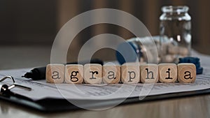 Word AGRAPHIA composed of wooden dices photo