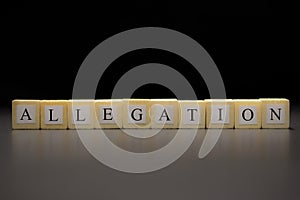 The word ALLEGATION written on wooden cubes isolated on a black background