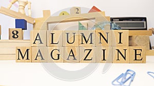 The word Alumnus magazine was created from wooden cubes. close up photo