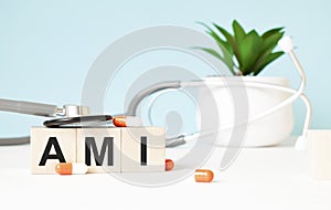 The word AMI is written on wooden cubes near a stethoscope on a wooden background. Medical concept