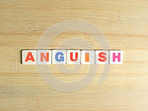 Word Anguish on wood background
