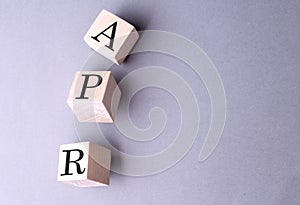 Word APR on the wooden block on the grey background